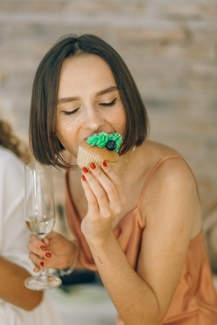 A Woman Eating A Cupcake