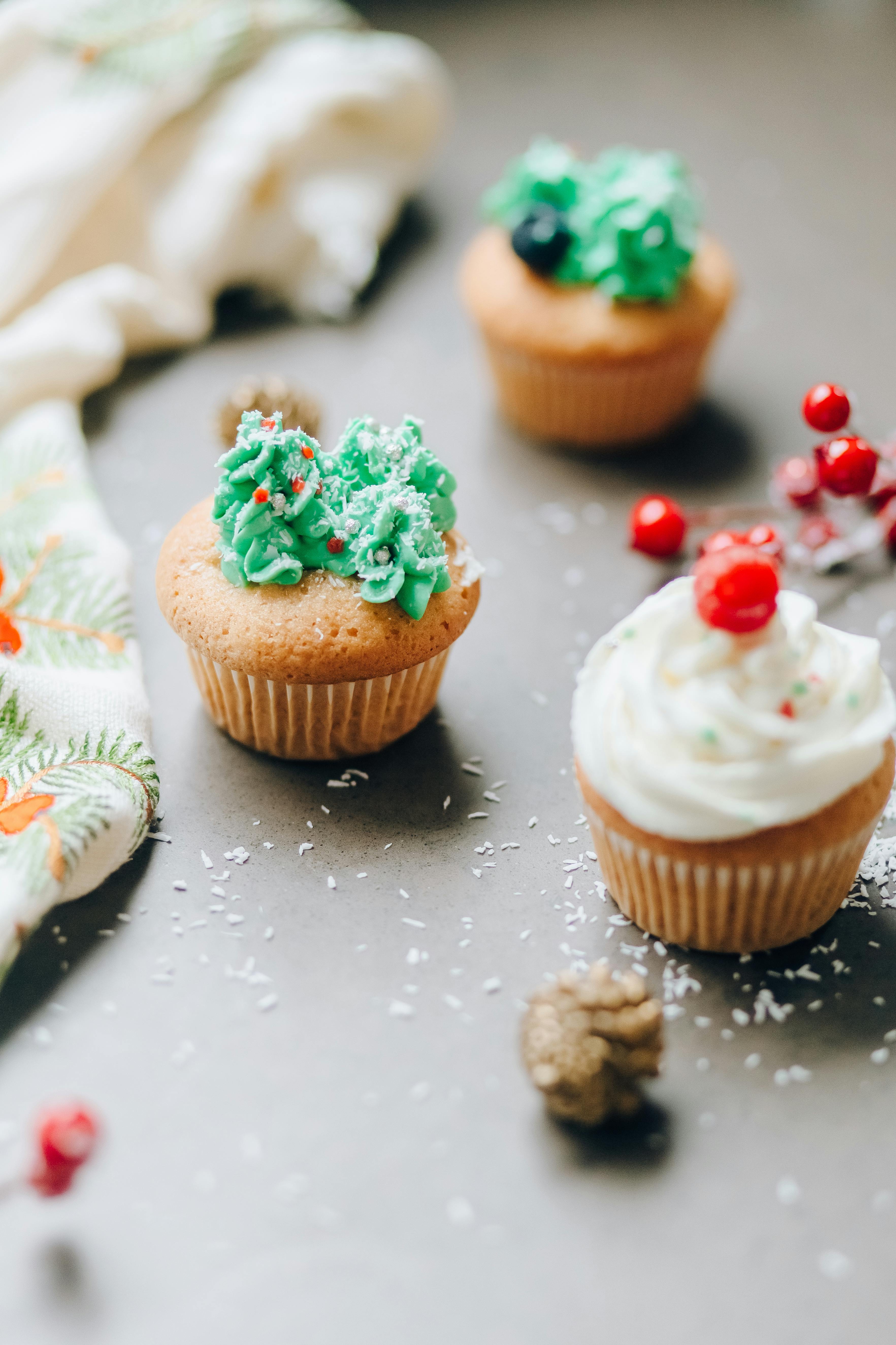 Close-up of festive cupcakes with holiday-themed decorations and vibrant frosting.