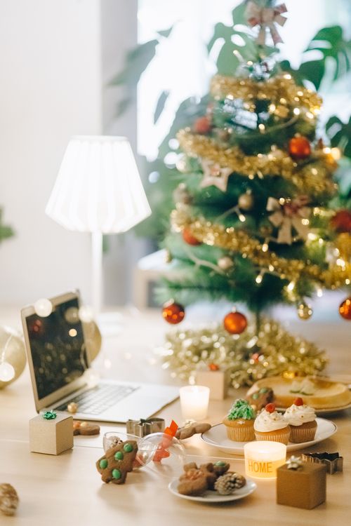 Free Cozy Christmas scene with decorated tree, cupcakes, and gifts creating a festive ambience. Stock Photo