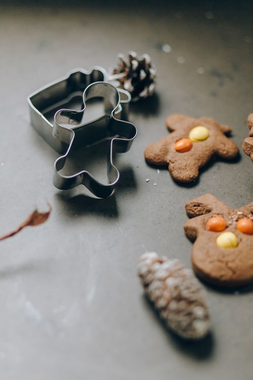 Free Gingerbread cookies with festive decorations and metal cutters on a table. Stock Photo