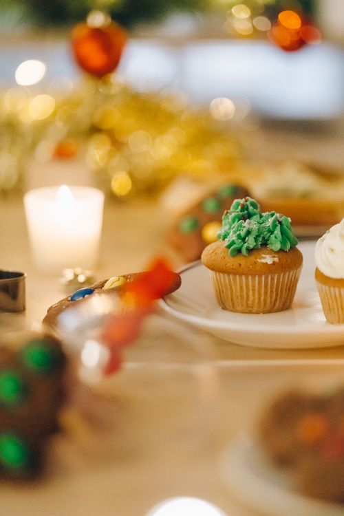 Free Close-up of decorated cupcakes with Christmas ornaments on a festive table setting. Stock Photo