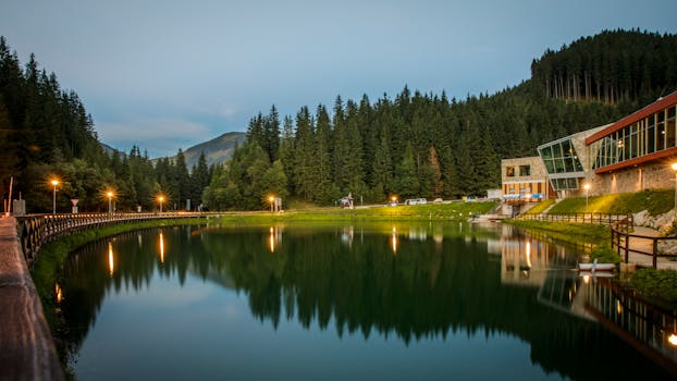 Tranquil lake view surrounded by forest and mountains at sunset in Demänovská Dolina, Slovakia.