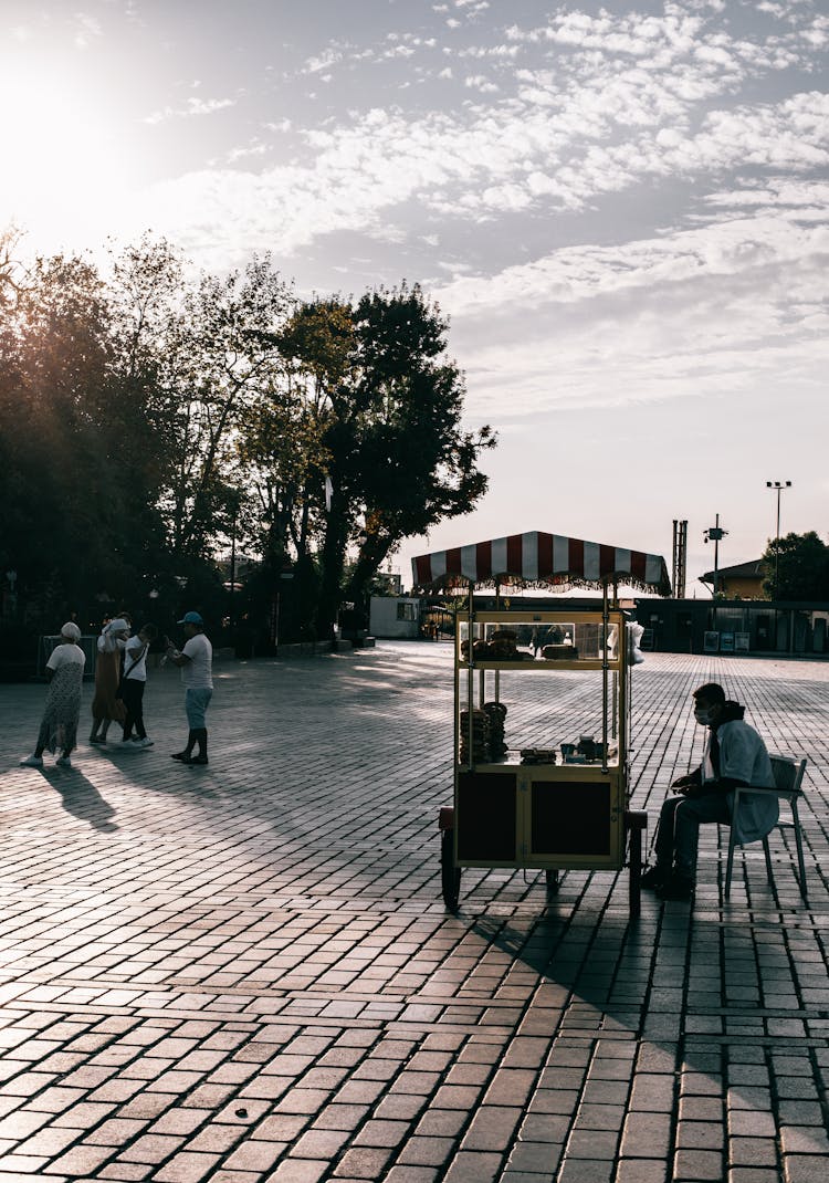 A Vendor Selling Food Using A Cart On The Street