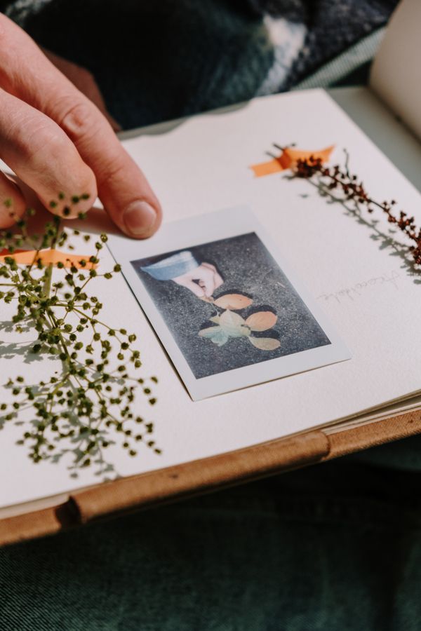 Beginner arranging photographs and decorative paper while learning aesthetic scrapbook page design