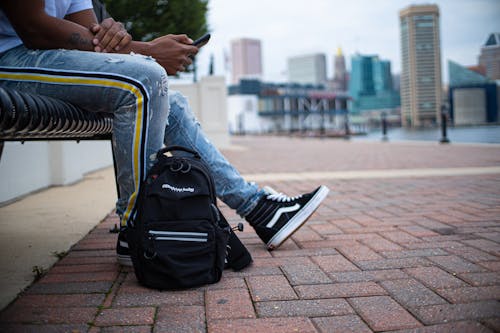 A Person in Blue Denim Jeans and Black and White Sneakers