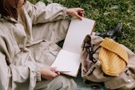 Woman Sitting on the Grass with an Open Scrapbook