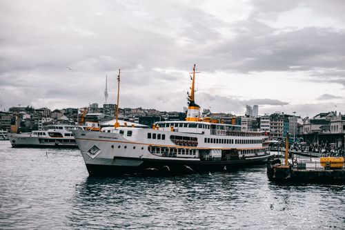 Free Large passenger ferry docked in Istanbul harbor with city skyline in the background. Stock Photo