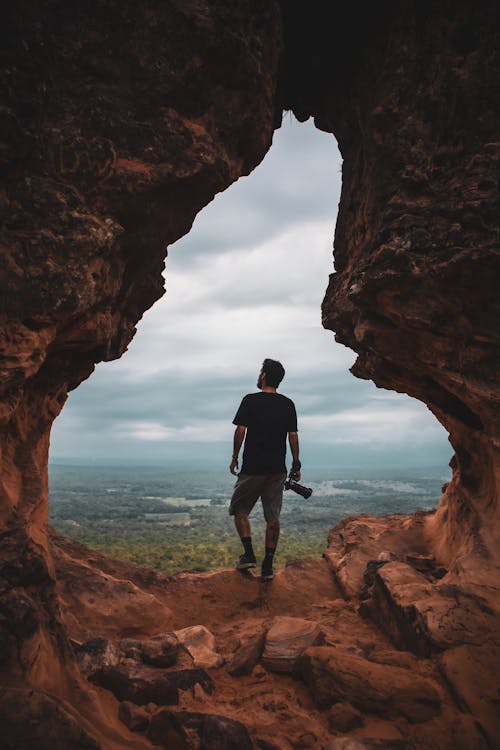 A Man Standing on Brown Rock Formation