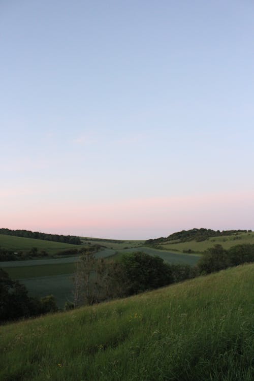 Gratis stockfoto met blauwe lucht, groen gras, heuvels