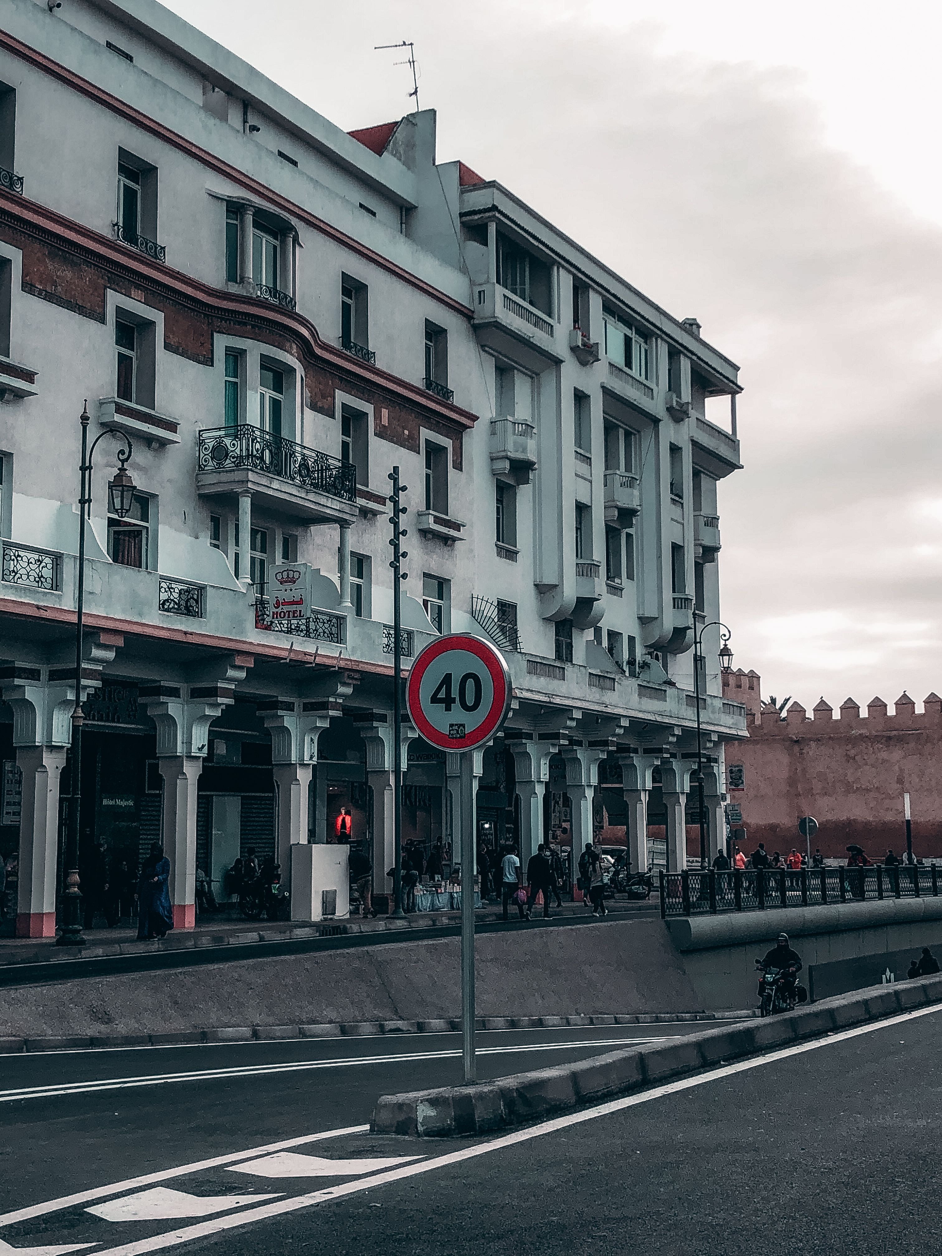 Capture of historic architecture and street life in Rabat, showcasing a speed limit sign and colonial-style buildings.