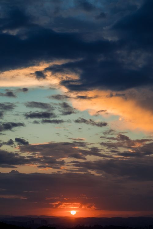 Free Captivating sunset with vibrant red sun and dramatic sky, ideal for nature themes. Stock Photo