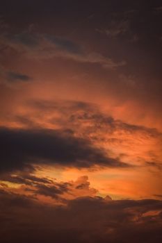 Vivid orange sunset with dramatic clouds creating a captivating sky scene.