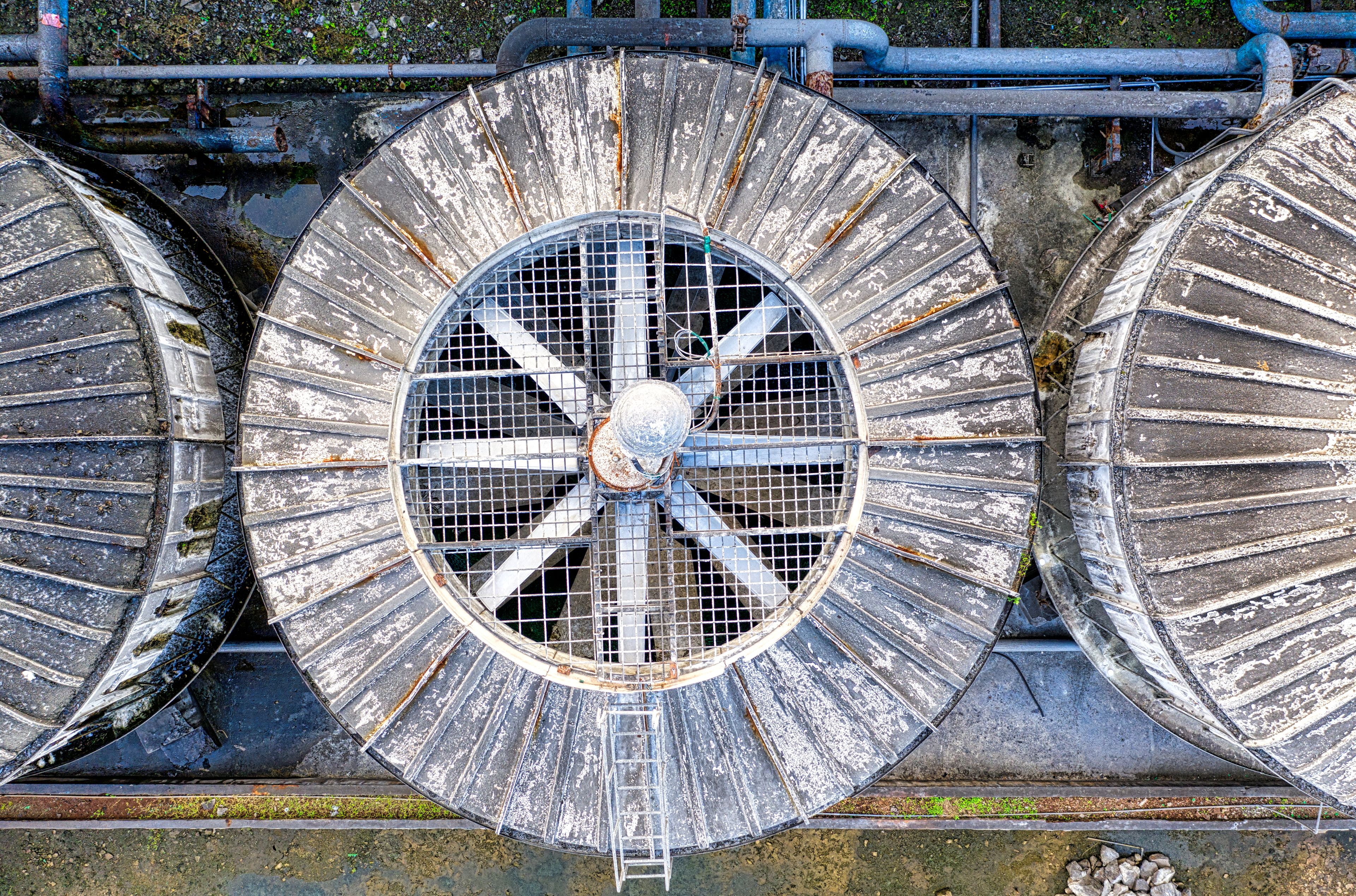 Vue aérienne de caissons d'extraction métalliques vieillissants installés en toiture parmi les conduits