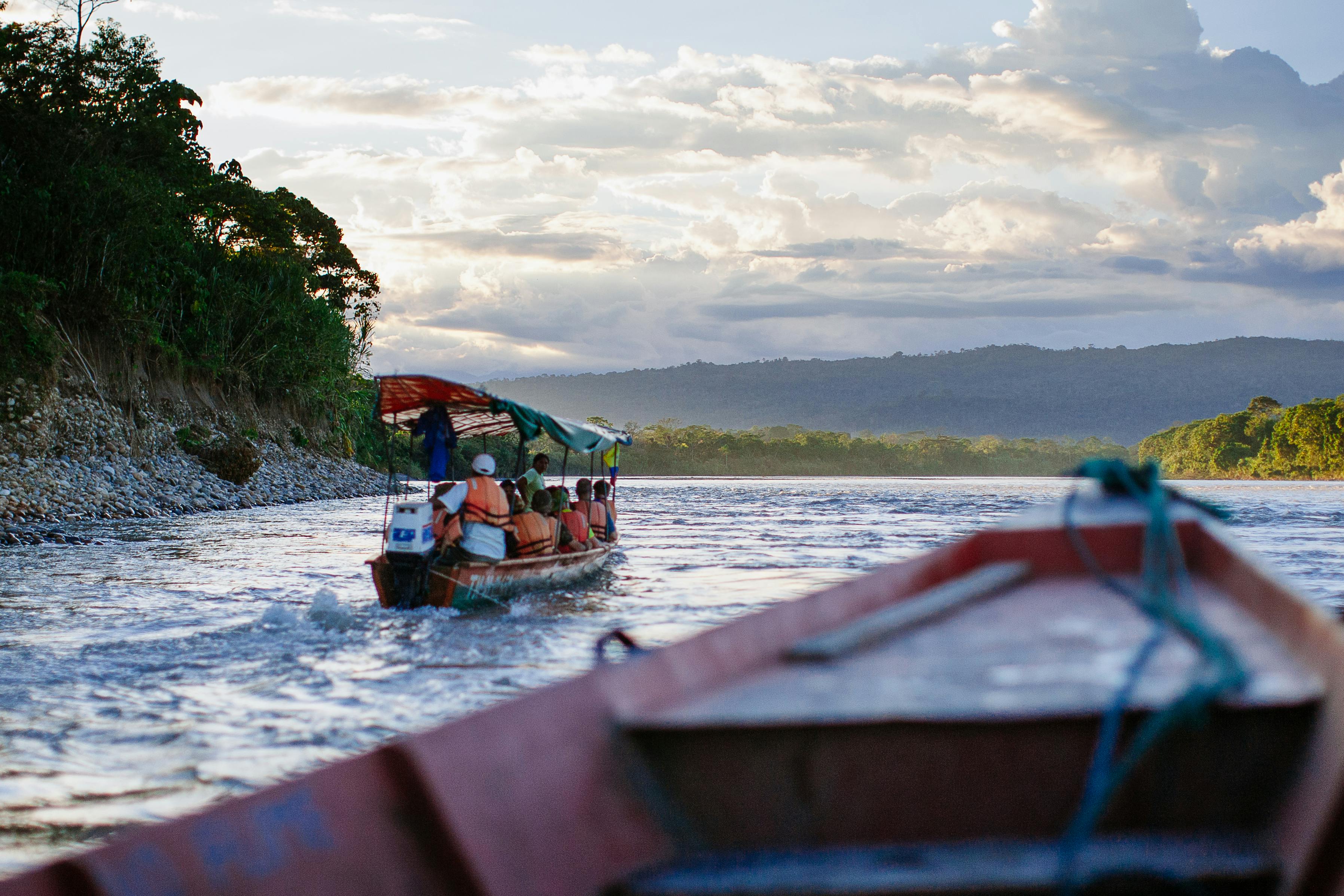 people riding a boat on body of water