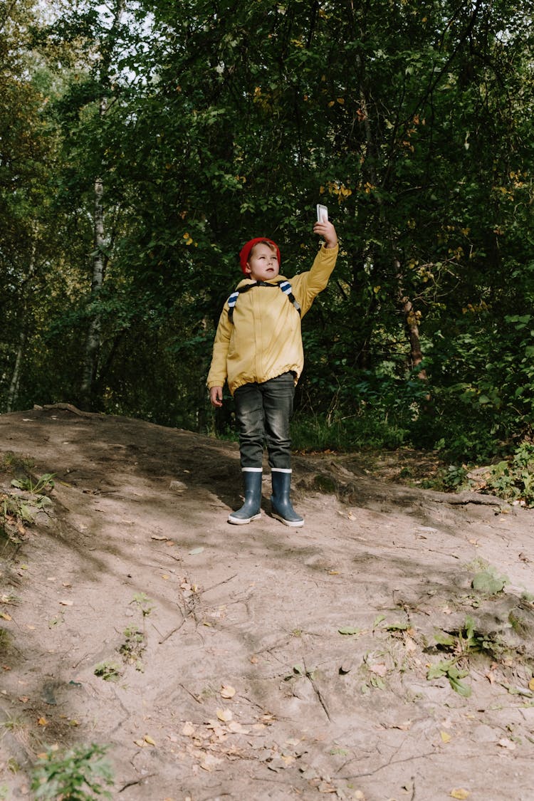 A Kid Looking For Signal In The Forest 