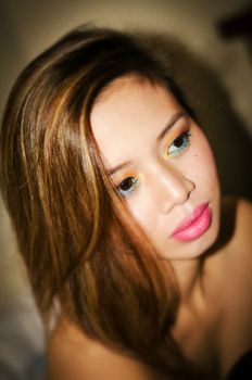 Close-up portrait of a woman with vibrant makeup, highlighting her features.
