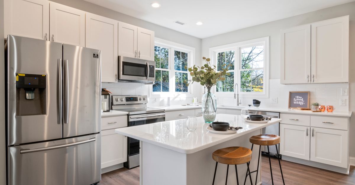 Bright modern kitchen with white cabinets and stainless steel appliances