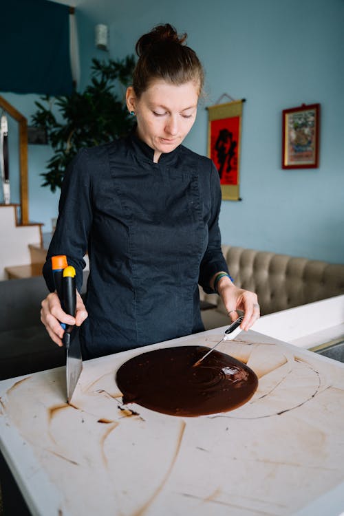 A Woman Checking the Temperature of the Melted Chocolate Using Thermometer