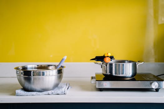 A kitchen scene featuring cookware with a striking yellow wall background.