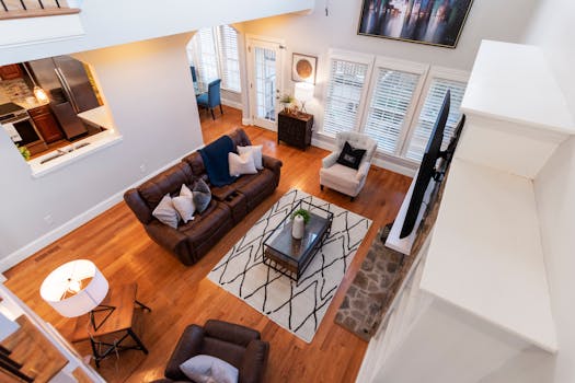 Elegant living room with leather sofas, soft lighting, and modern decor viewed from above.