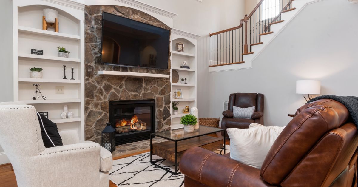 Warm and inviting living room with stone fireplace and modern furniture.