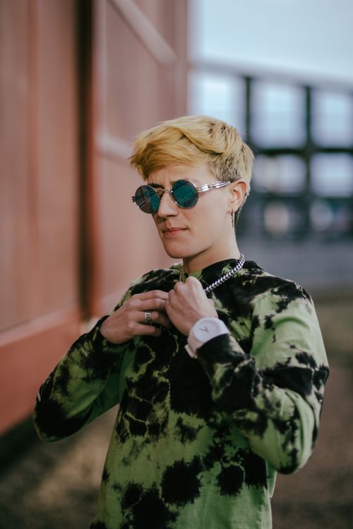 Free Fashionable young adult wearing sunglasses and tie-dye shirt outdoors in Kansas City. Stock Photo