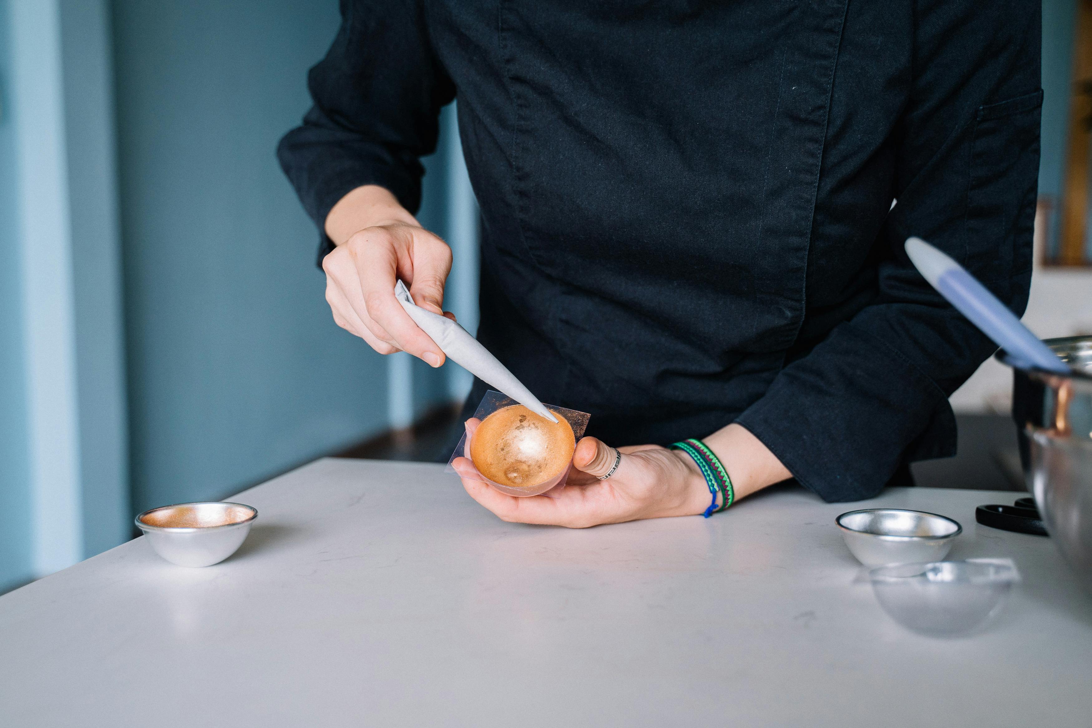 A chef carefully decorating a dessert with intricate details