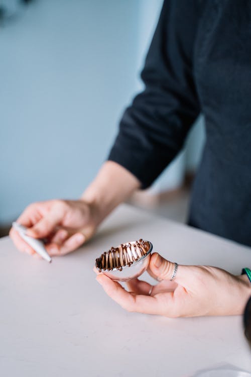 Persona Che Tiene Il Cioccolato A Strisce Bianche E Marroni