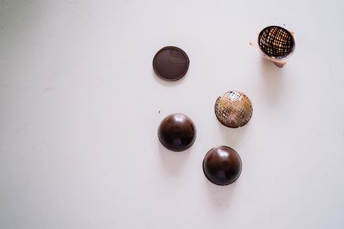 Free Delicate arrangement of chocolate spheres showcasing a modern food art concept on a white surface. Stock Photo