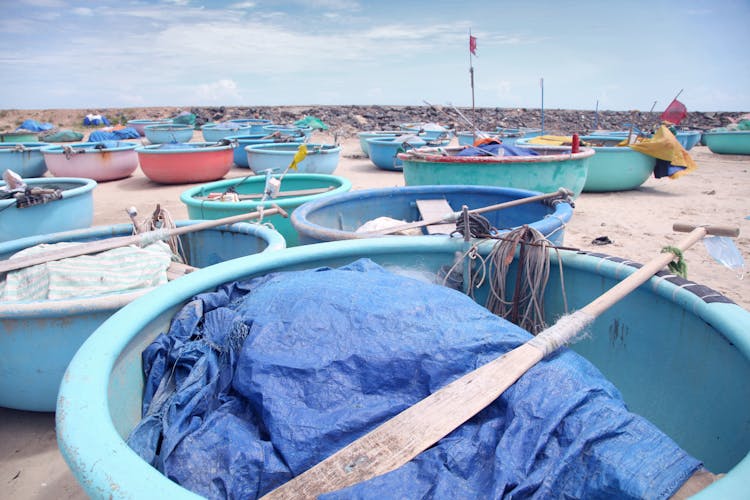 Many Round Fishing Boats Moored On Sandy Shore