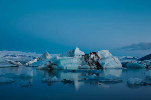 Free Stunning landscape of icebergs floating in serene waters under a clear sky in Iceland. Stock Photo