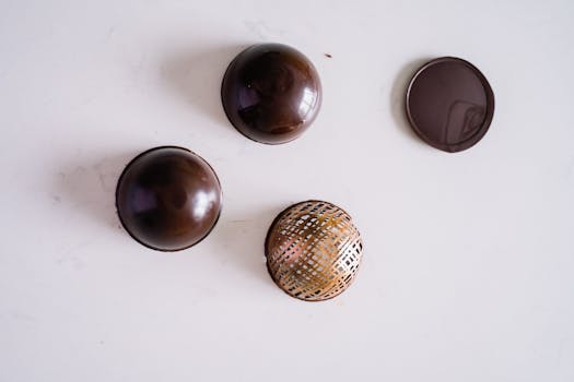 Delicate chocolate desserts with artistic patterns on a clean white surface, perfect for food photography.