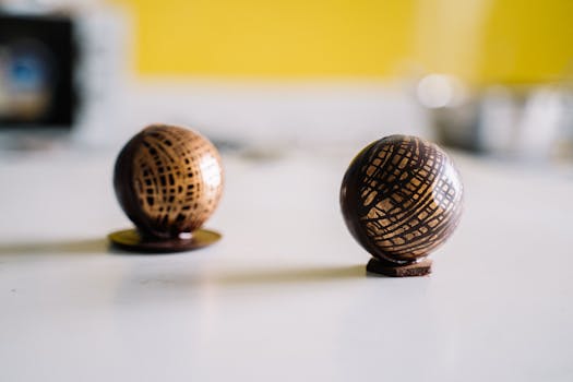 Close-up of exquisite chocolate spheres with artistic patterns on a white table.