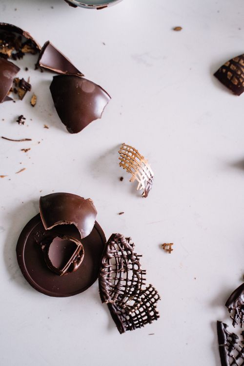 Free Flat lay of broken chocolate pieces scattered on a white surface, creating a minimalist still life. Stock Photo