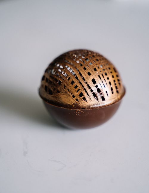 Free Close-up of a decorative chocolate sphere with intricate lattice design. Stock Photo