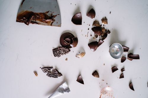 Free Top view of broken chocolate pieces and kitchen tools on a white surface. Stock Photo