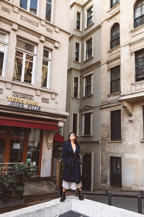 Free Fashionable woman stands confidently in a European urban street setting. Stock Photo