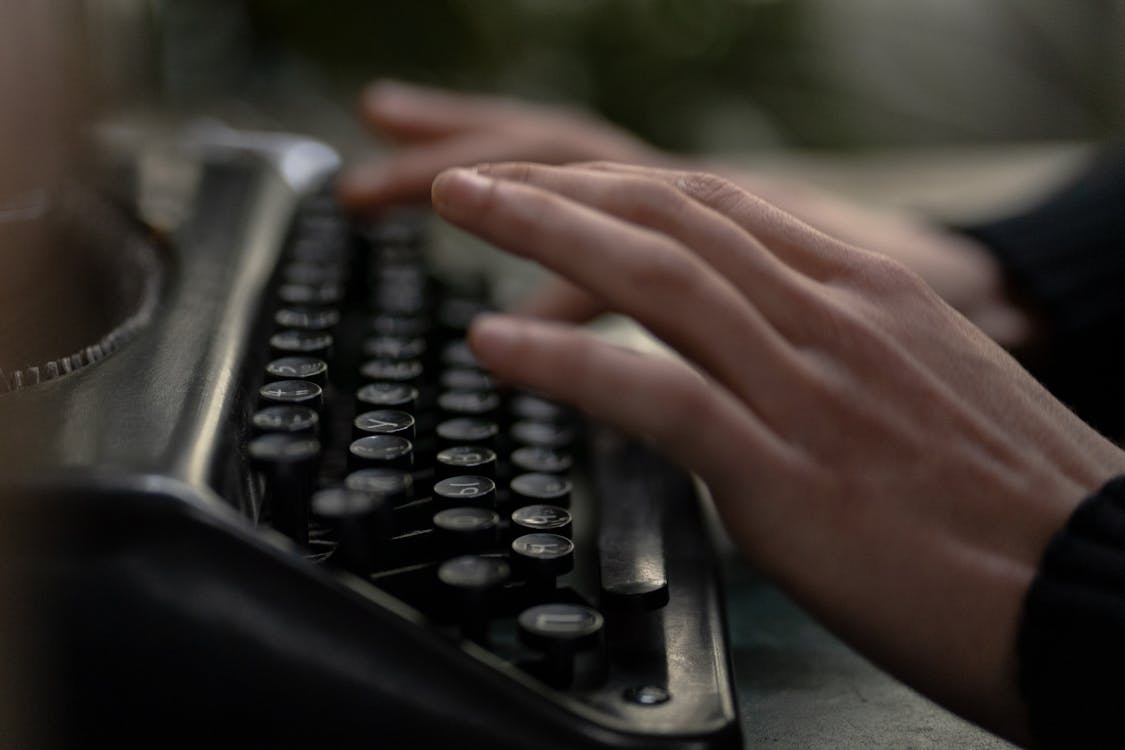 Close-up of Hands Using a Typewriter · Free Stock Photo