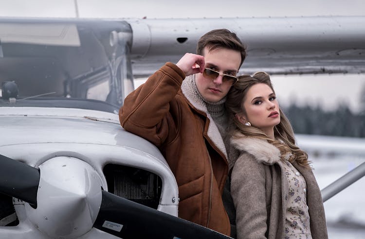 Stylish Couple Embracing Near Propeller Jet