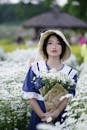 Charming Asian woman on plantation with blooming flowers
