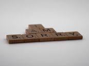 Brown Wooden Scrabble Pieces on White Surface