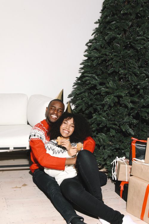Free A happy couple celebrating Christmas with gifts and a tree indoors. Stock Photo