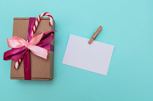 Blank postcard with clip arranged with present box decorated with candy cane