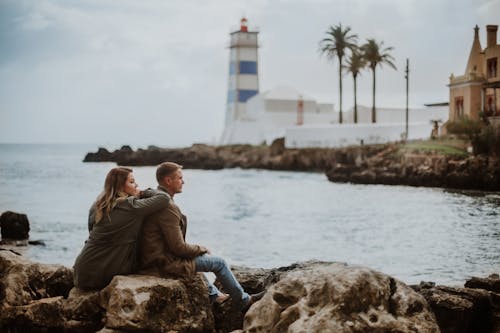 Casal relaxa à beira do farol