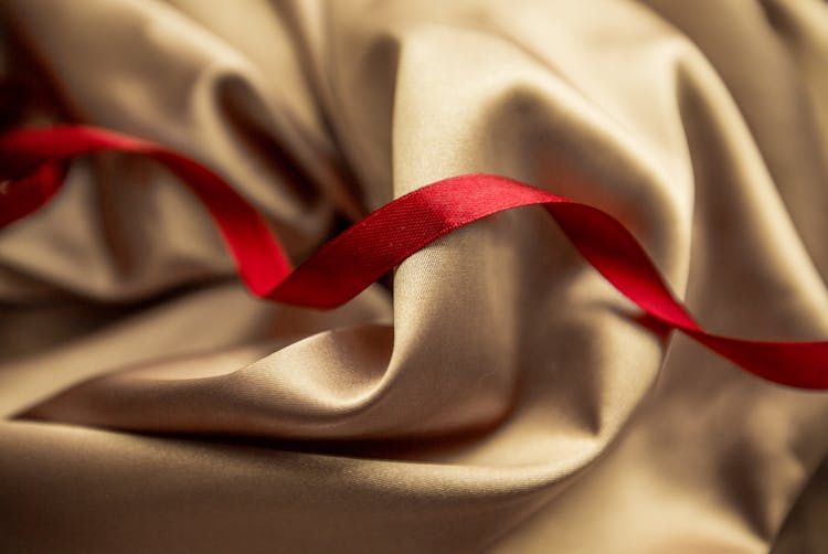 Red Satin Ribbon On Golden Silk Cloth