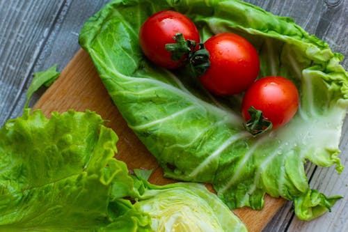 Fresh green leaf lettuce and bright red tomatoes arranged on table