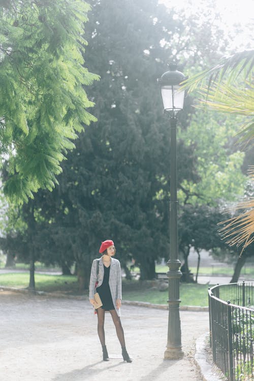 Woman Standing Beside a Street Lamp