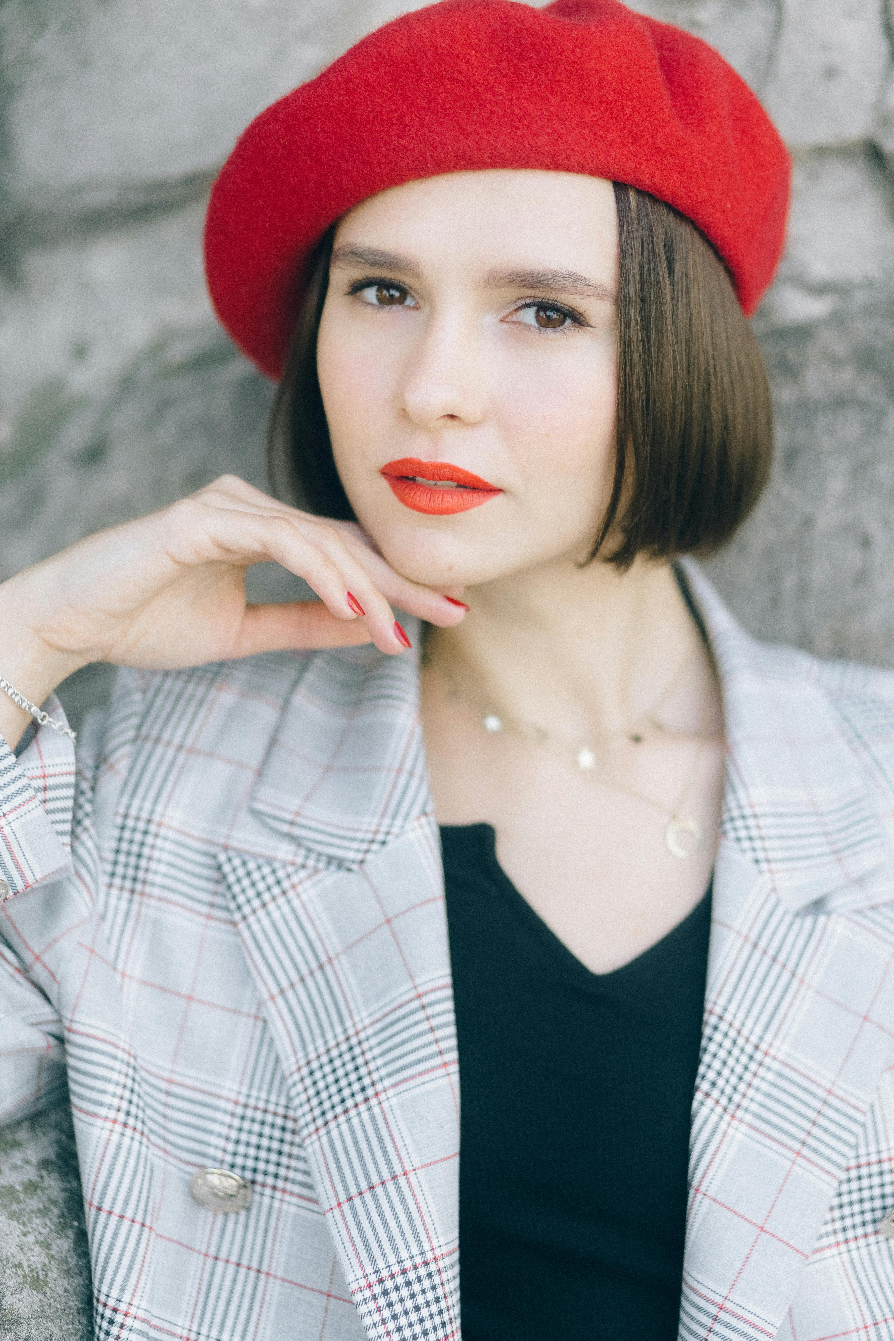 woman wearing a beret with hand on chin