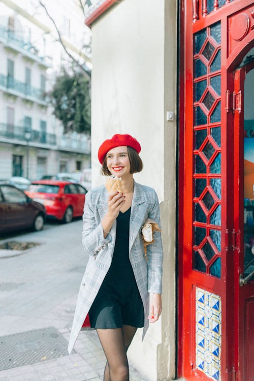 Woman Holding a Bread Walking Beside the Doorway
