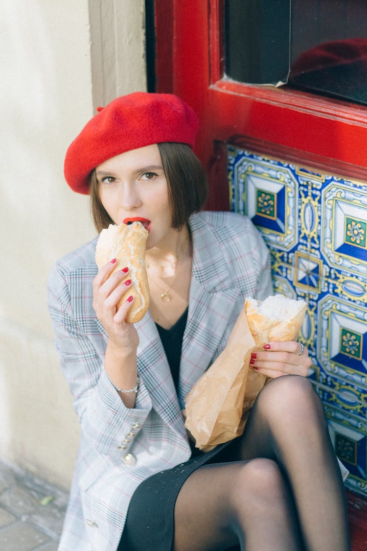 Woman In Red Beret Hat Eating Bread